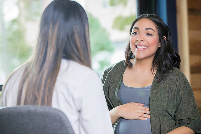 young pregnant woman consulting with doctor